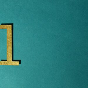 A gold number one on a teal background with ample copy space.