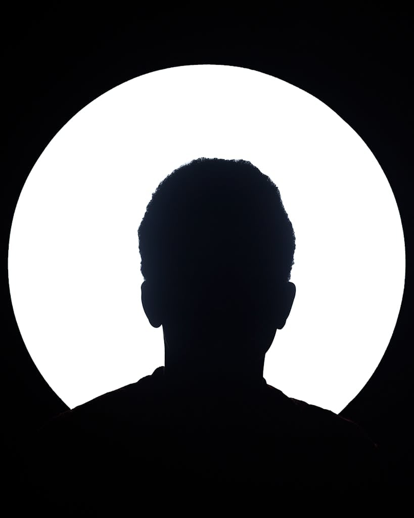 Artistic silhouette of an unknown person against a bright circular light background. - Become a Founding Member of HDY Haus Community & Studio